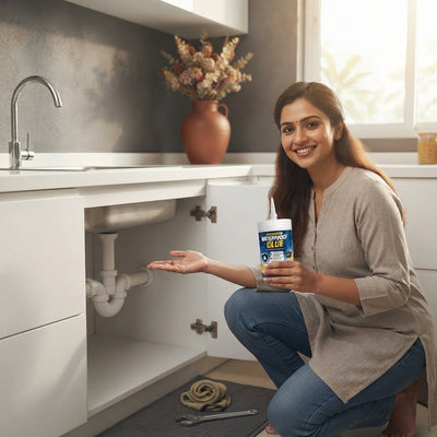 South Asian homeowner holding transparent waterproof glue in a modern kitchen after a successful DIY repair.